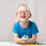 laughing boy coloring on desk