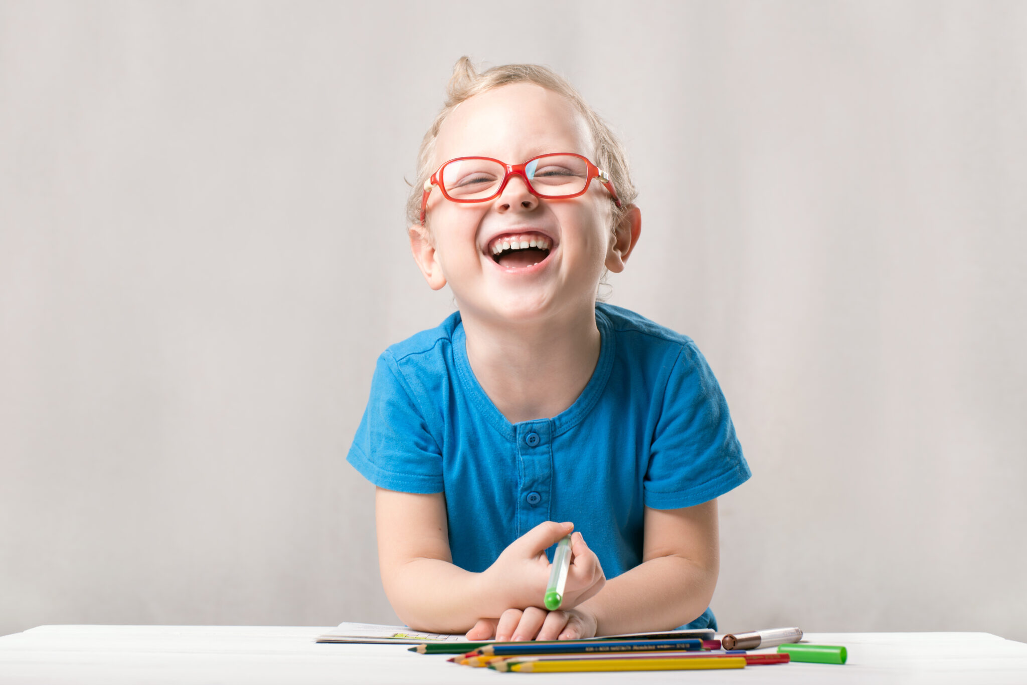 laughing boy coloring on desk